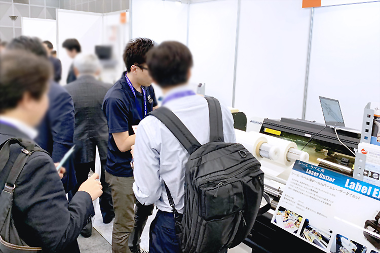ラベルフォームジャパン2019でコムネット株式会社はシール・ラベル向け小ロット生産に適したレーザー加工機（レーザーカッター）をお客様にご案内いたしました。