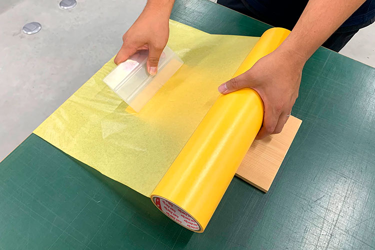レーザーカッター・レーザー加工機で、かまぼこ彫りの木彫り看板製作：マスキングテープを貼りつける