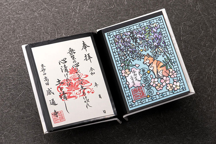 御朱印帳に美しく収められた、藤の花と柴犬デザインの切り絵御朱印